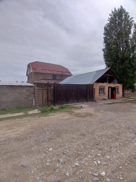 a barn with a building with a red roof at Abylay Guesthouse in Jangy-Talap