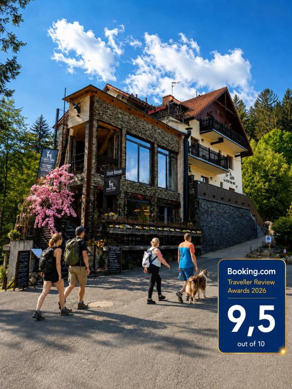 a group of people walking a dog in front of a house at Safir przy samym WYCIĄGU in Karpacz