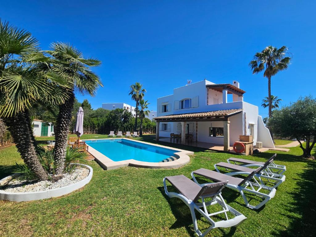 a villa with a swimming pool and lounge chairs at Casa Sylvia Cala D'OR in Cala d´Or