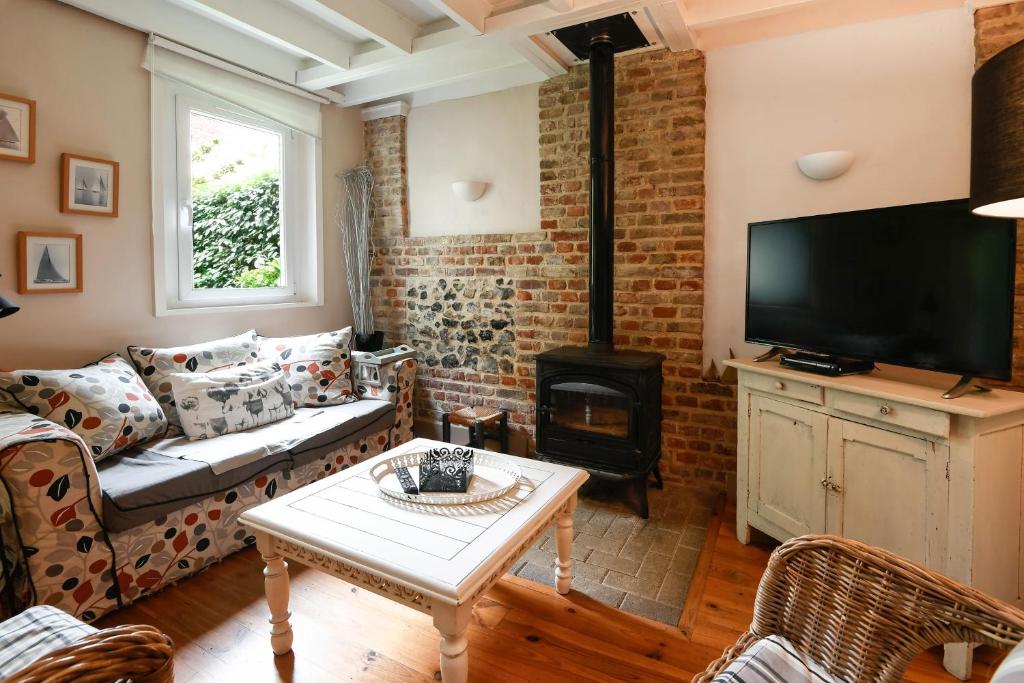 a living room with a couch and a fireplace at Cottages Croix L'abbé, les Mouettes in Saint-Valéry-sur-Somme