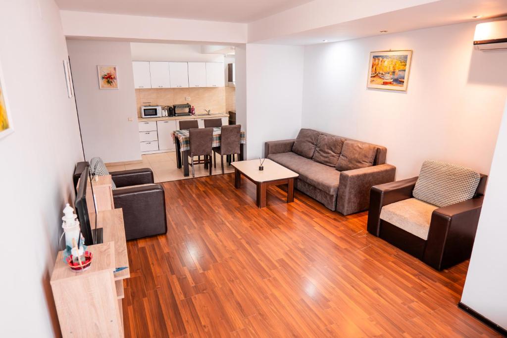 a living room with a couch and a table at Summerland Lake View Apartament in Mamaia