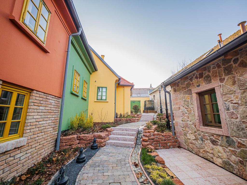 a cobblestone alley between two colorful houses at Platán Utca - Platán Tata in Tata