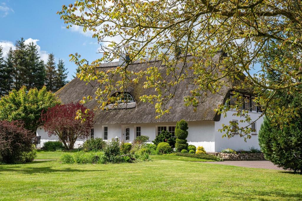 a white house with a thatched roof at Haus am See in Witzin