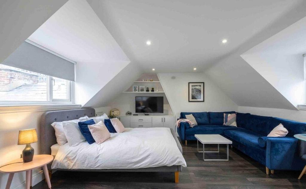 a bedroom with a bed and a blue couch at Aquila House in Saint Helier Jersey