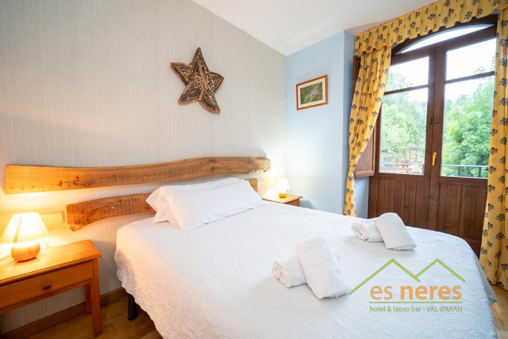 a bedroom with a bed with white sheets and a window at Casa Es Neres in Les