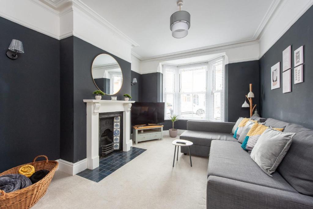 a living room with a gray couch and a mirror at Spacious 3 Bed In Rugby in Rugby
