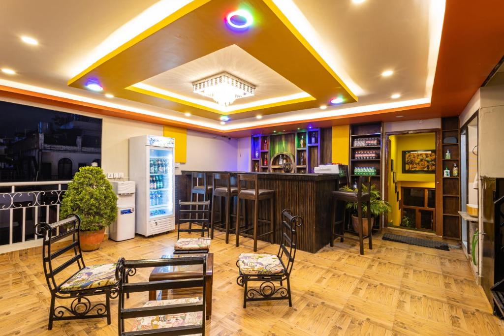 a room with a bar with chairs and a counter at Hotel Outfitter Nepal in Kathmandu