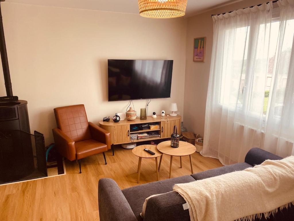 a living room with a tv and a couch and a chair at Cap d'Equih' in Équihen-Plage