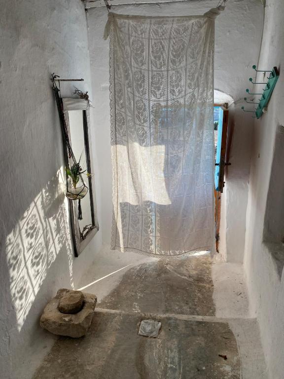 a hallway with a window and a curtain in a room at Evnomia Cycladic Home from 1912 in Mélanes