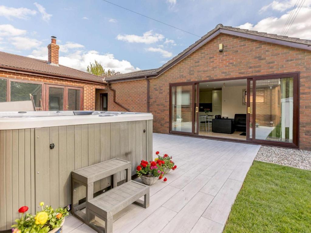 a backyard with a deck with a bar and a house at 1 Bed in Cinderford oc-82884 in Cinderford