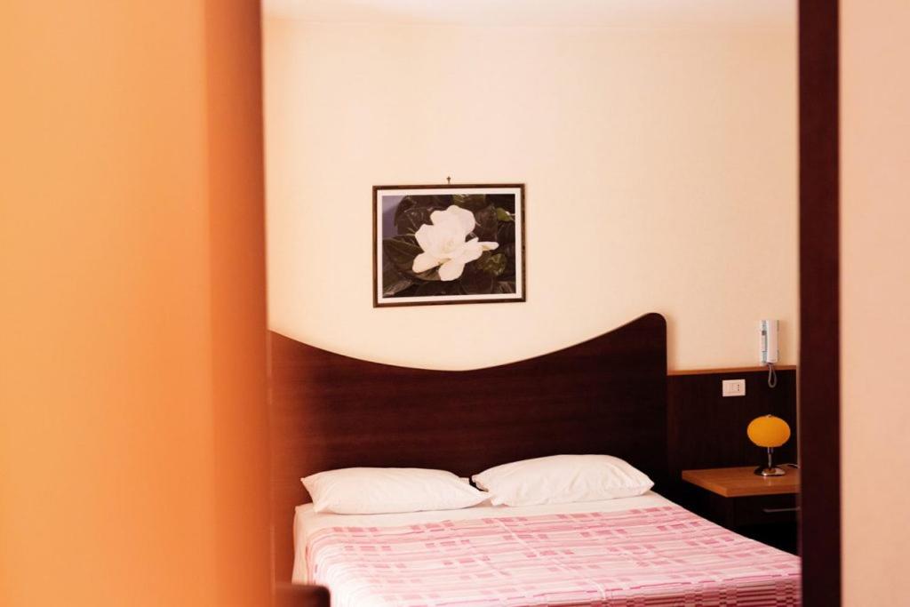 1 dormitorio con 1 cama y una foto en la pared en A'Luara en San Roberto