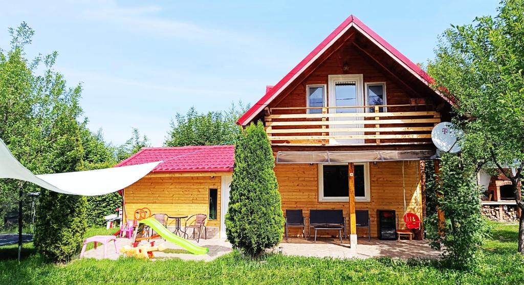 a log cabin with a playground in front of it at AMA Bliss Nature & Cozy Cabin in Avrig