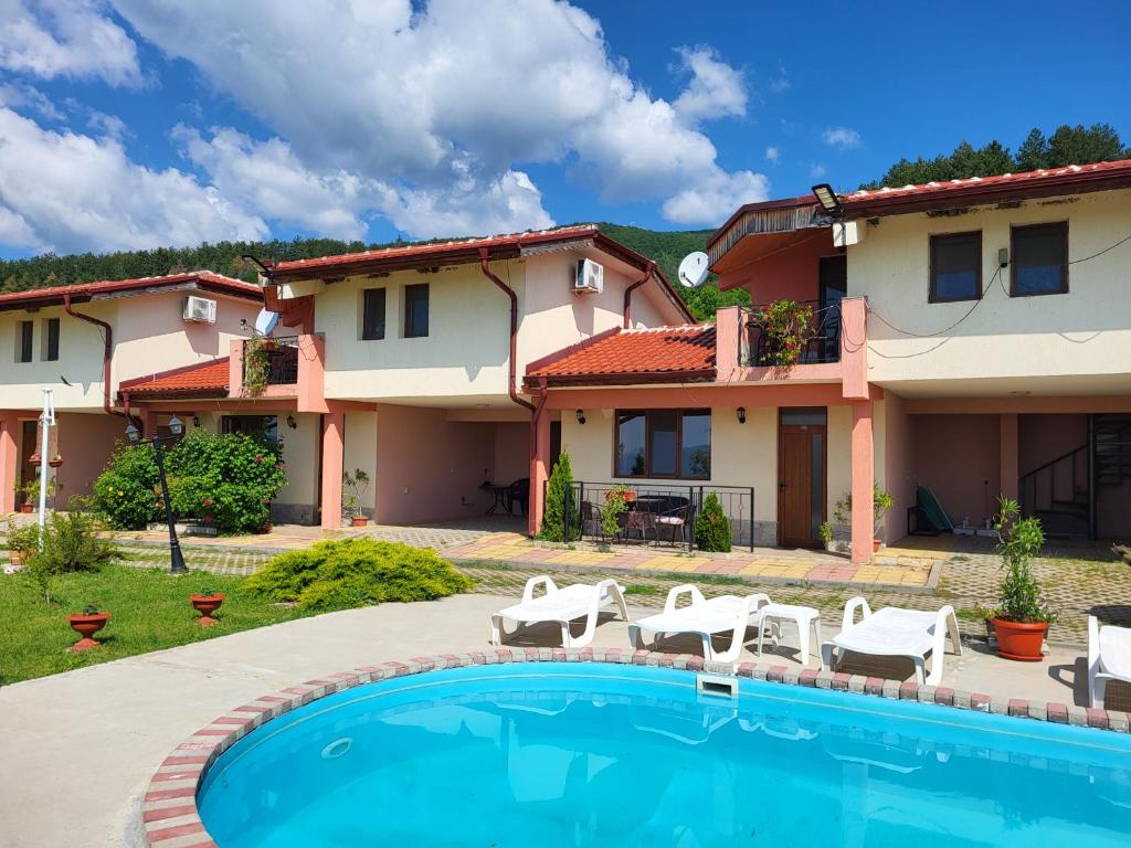 a villa with a swimming pool in front of a house at Гледката in Mŭdren