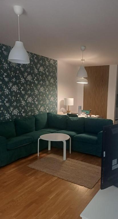 a living room with a green couch and a table at Stan in Zrenjanin