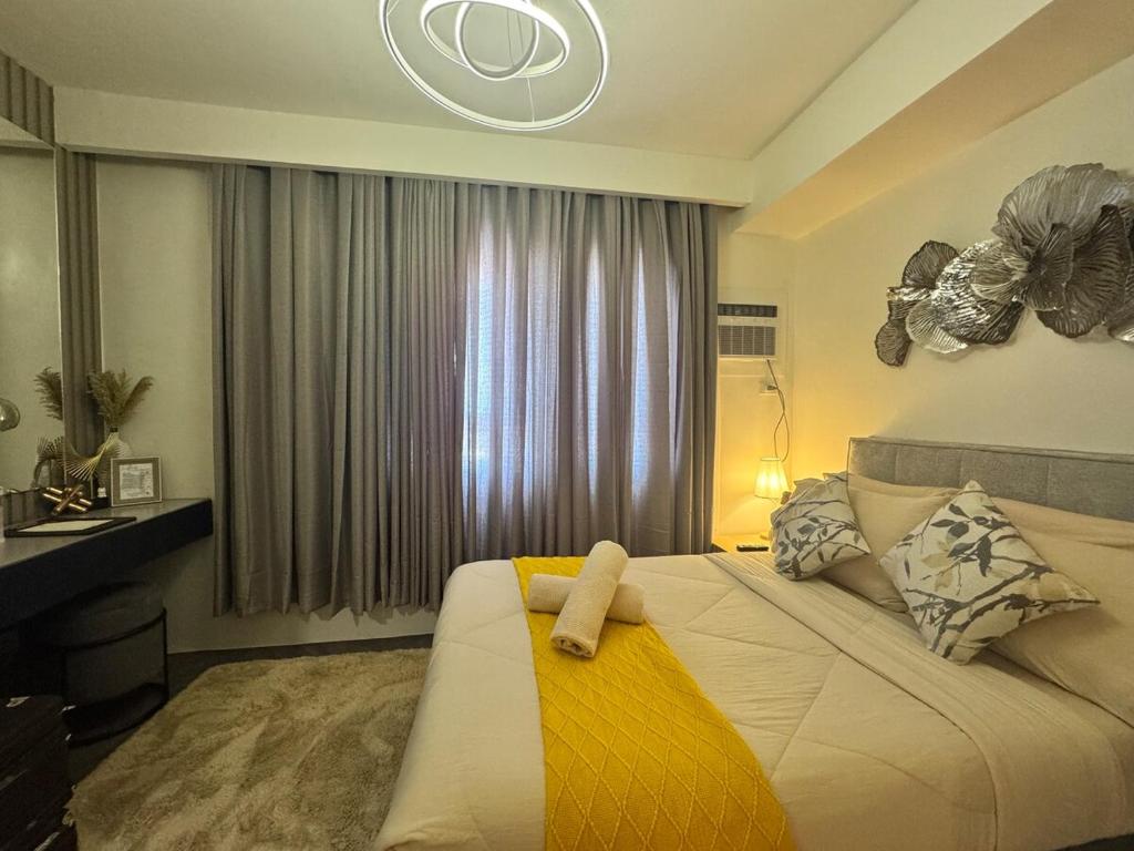 a bedroom with a bed with a yellow blanket on it at D Grey Pillows - 16th Floor One-Bedroom Condo Unit with Sea View in Pontud