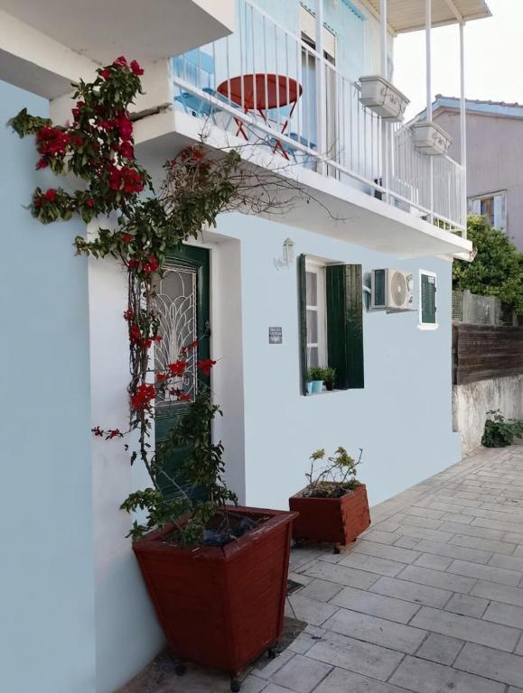 a white building with flowers on the side of it at Blau Haus Townhouse in Lefkada