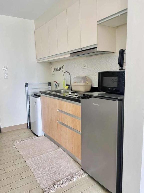 a kitchen with a sink and a stove and a refrigerator at Jaystaycation in Iloilo City