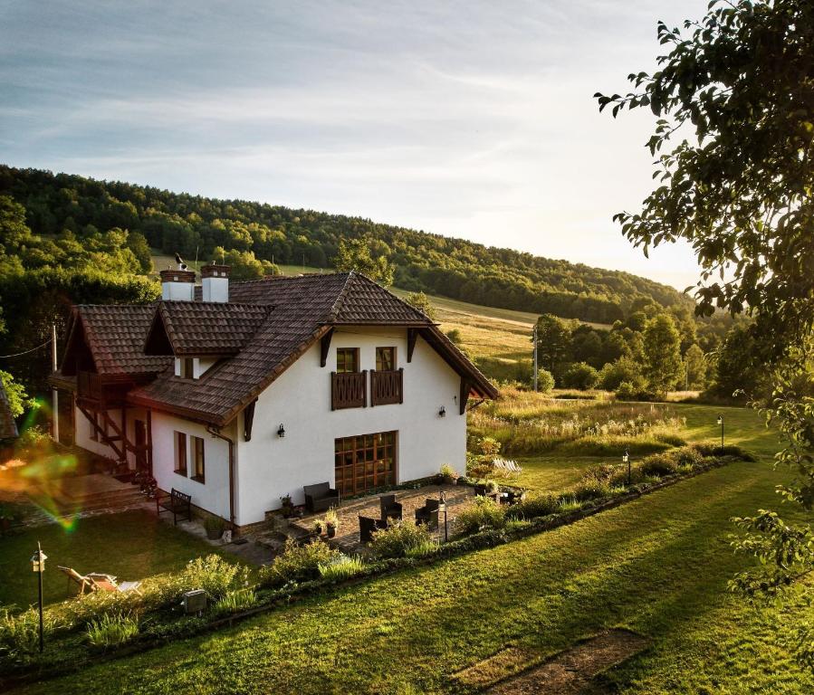 a white house in the middle of a field at Agroturystyka Akacjowe Zacisze- pokoje ze śniadaniami, sauna, balia, tarasy wśród drzew, slow life in Stańkowa