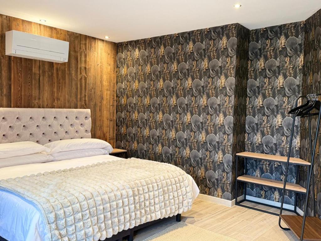 a bedroom with a bed and a wall covered in wallpaper at Casa Tramuntana in El Port de la Selva