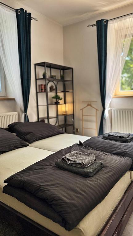 two beds in a bedroom with black and white at podZZamkem in Jaroslavice