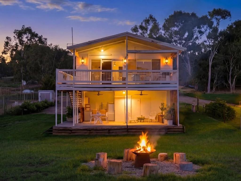 a house with a fire pit in the yard at Mudita at Bonnie Doon in Bonnie Doon