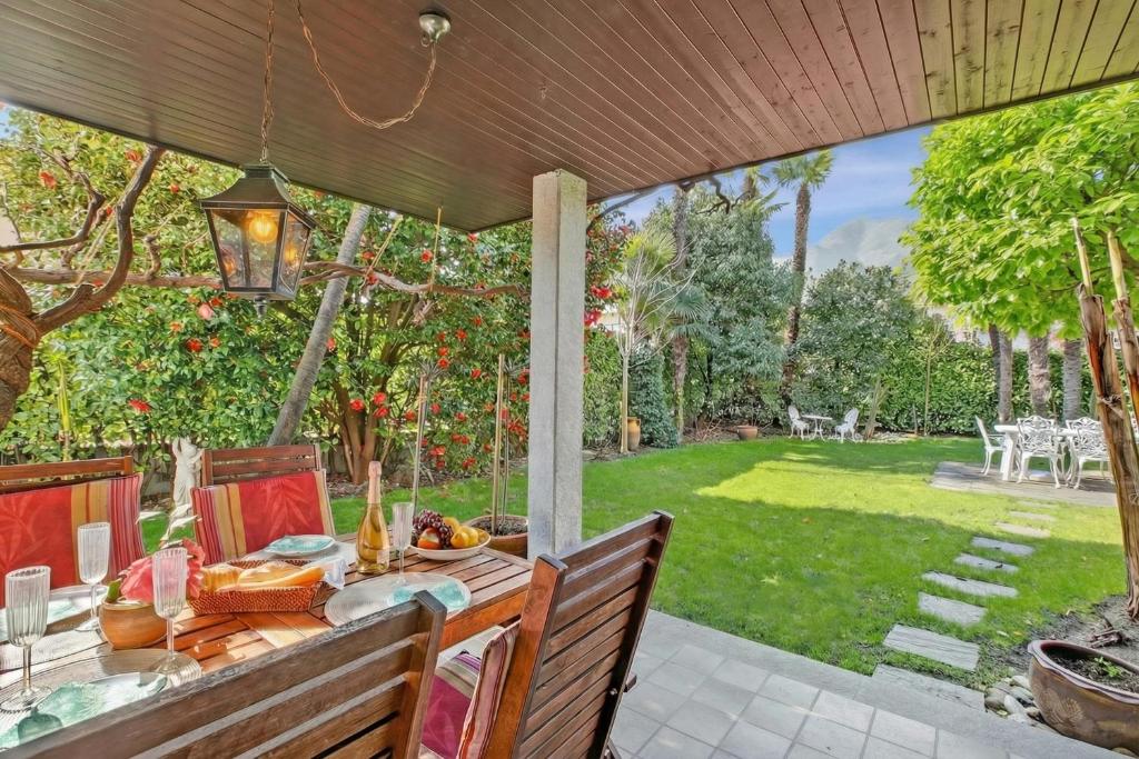 a table on a patio with a view of a yard at Casa Viola Losone for 8 - Happy Rentals in Losone
