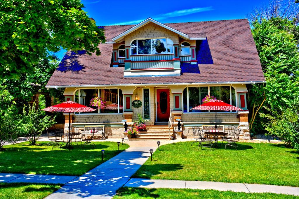 una casa con mesas y sombrillas en el patio en Bard's Inn, en Cedar City