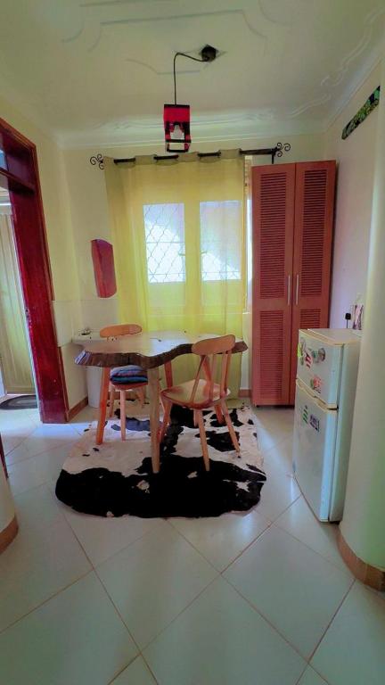 a kitchen with a table and chairs and a refrigerator at Malaika Villas in Kampala