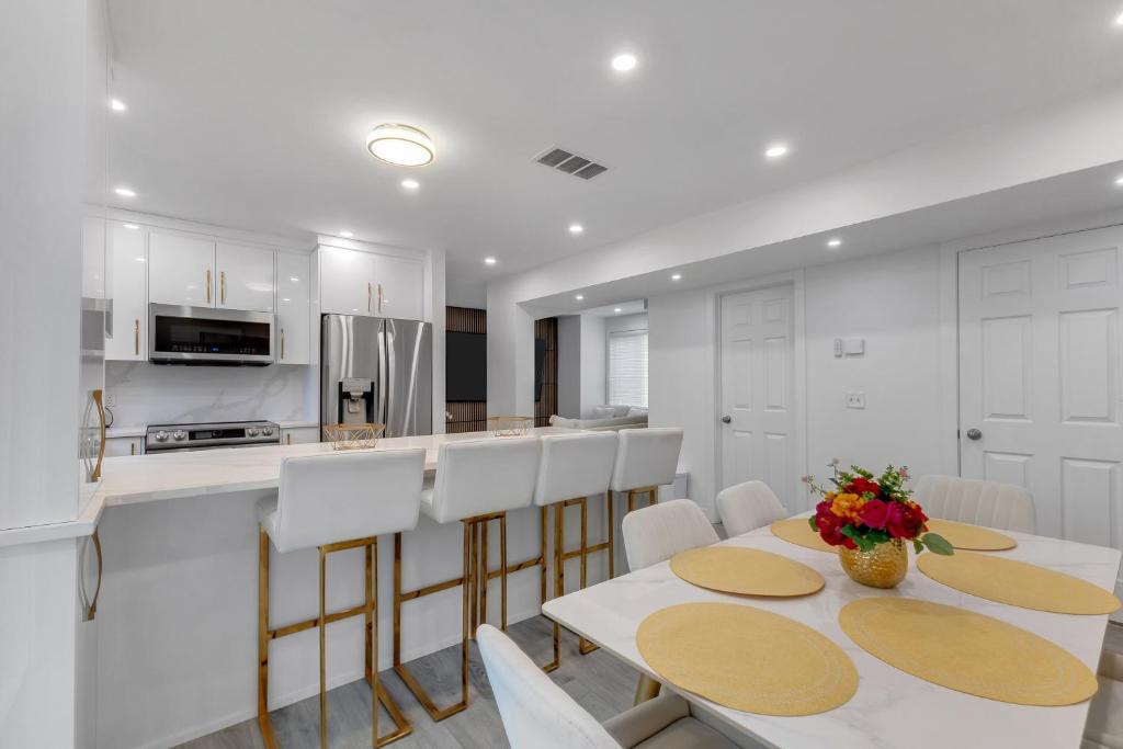 a kitchen with white cabinets and a table and chairs at Guest House in Calgary Downtown in Calgary