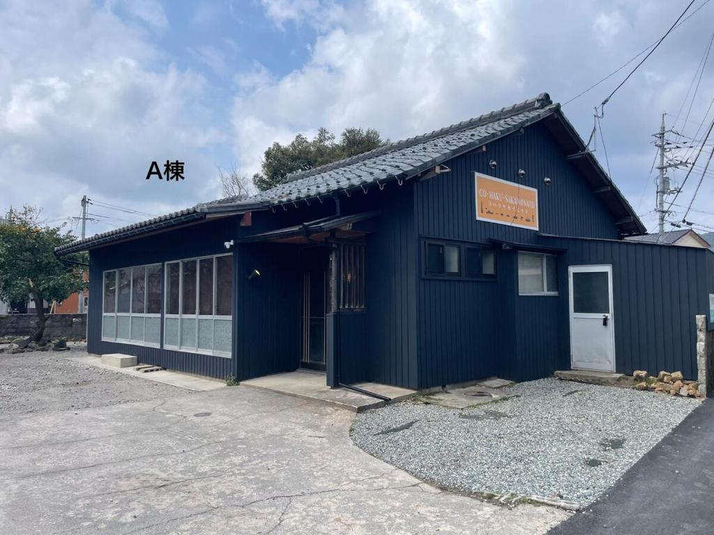 a blue building with a sign on top of it at コハクサカイミナト in Sakaiminato