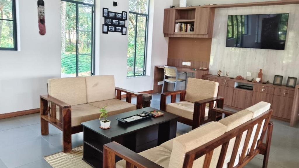 a living room with a couch and chairs and a table at Moner Pukur in Bolpur