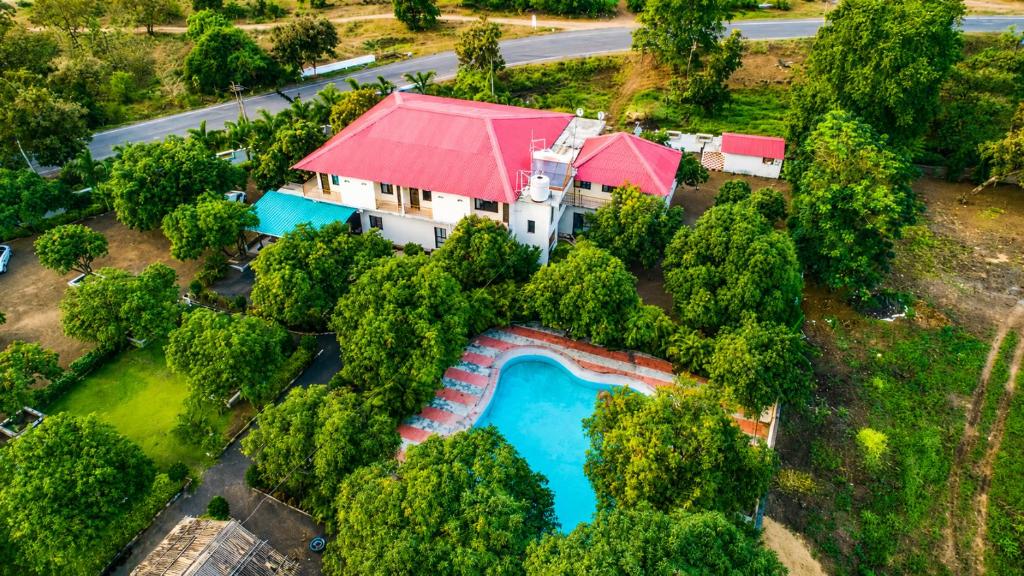 an aerial view of a house with a swimming pool at Vanveli The Forest Resort in Sasan Gir