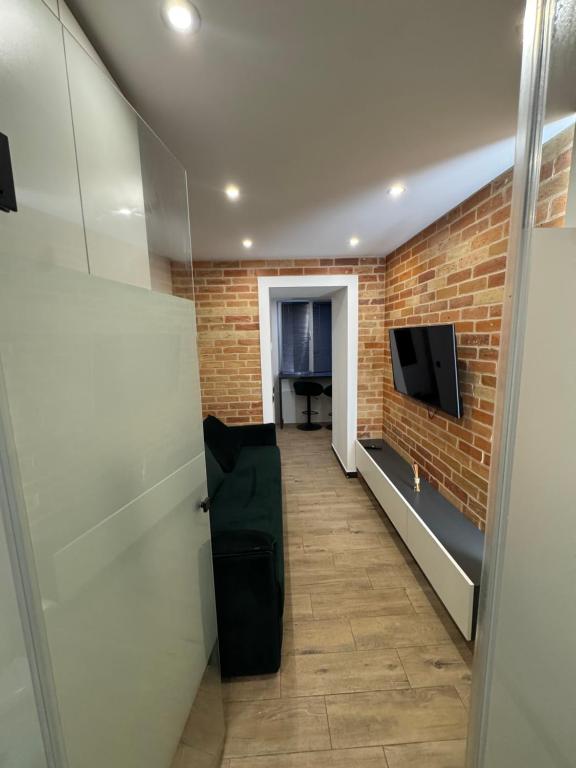 a hallway with a brick wall and a tv at Historical Apartments by Stepan Fedak in Lviv