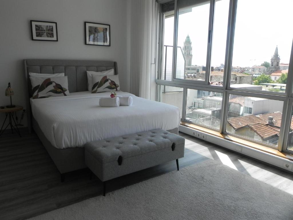 a bedroom with a white bed and a large window at Bolhão Skyline in Porto