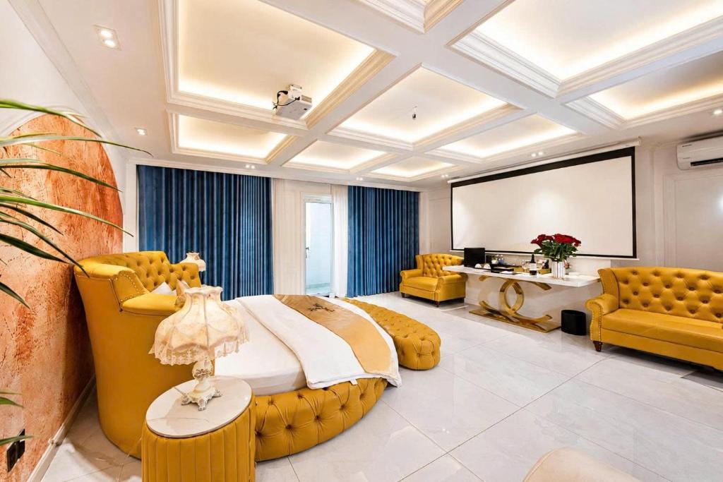 a large bedroom with a large bed and yellow furniture at Love Luxury Hotel Bà Điểm in Ho Chi Minh City