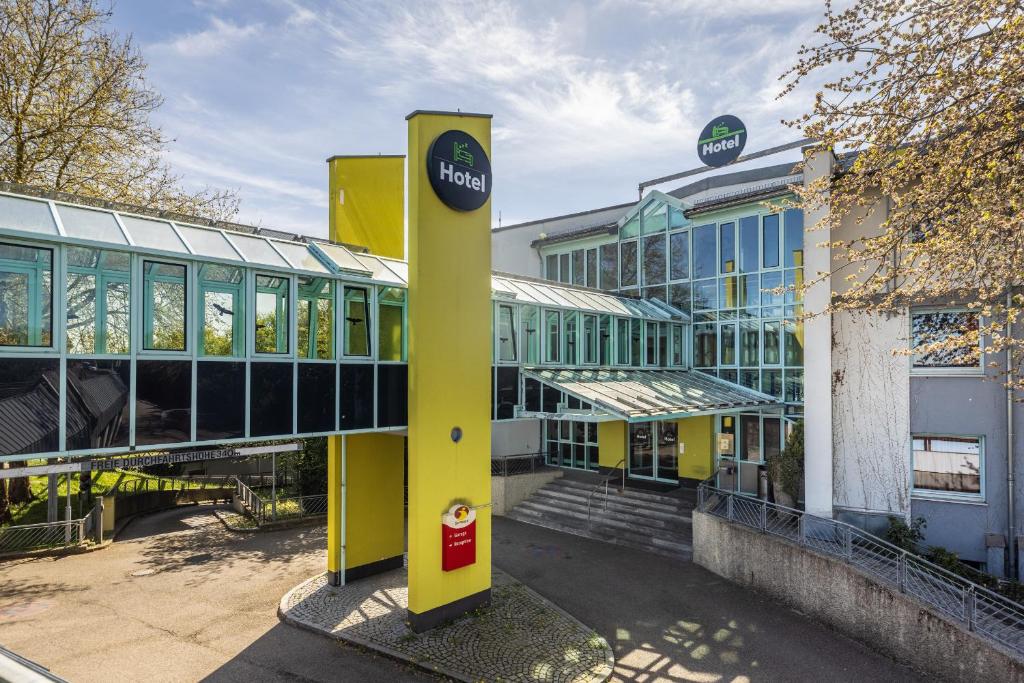 a building with a yellow pole in front of it at Hotel Holledau in Geisenhausen
