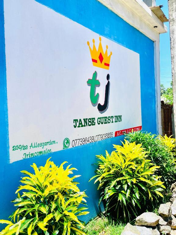 a sign for jase guest inn with a crown on it at TJ JANSE guest inn in Trincomalee
