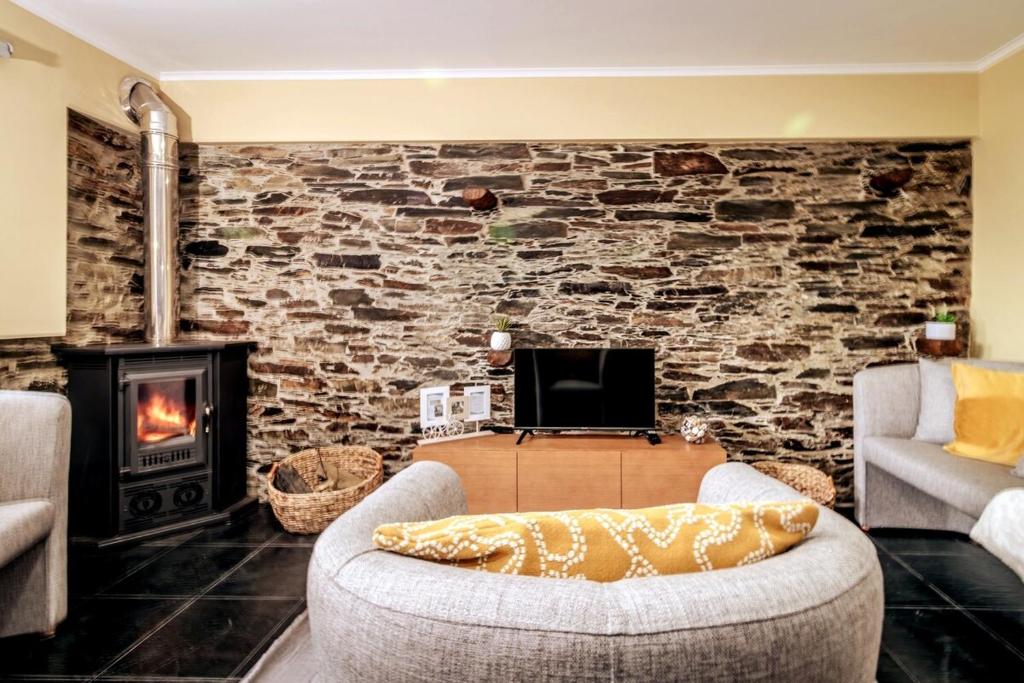 a living room with a couch and a fireplace at Férias na Serra # Natureza # Casa da Professora By ALzira in Seia