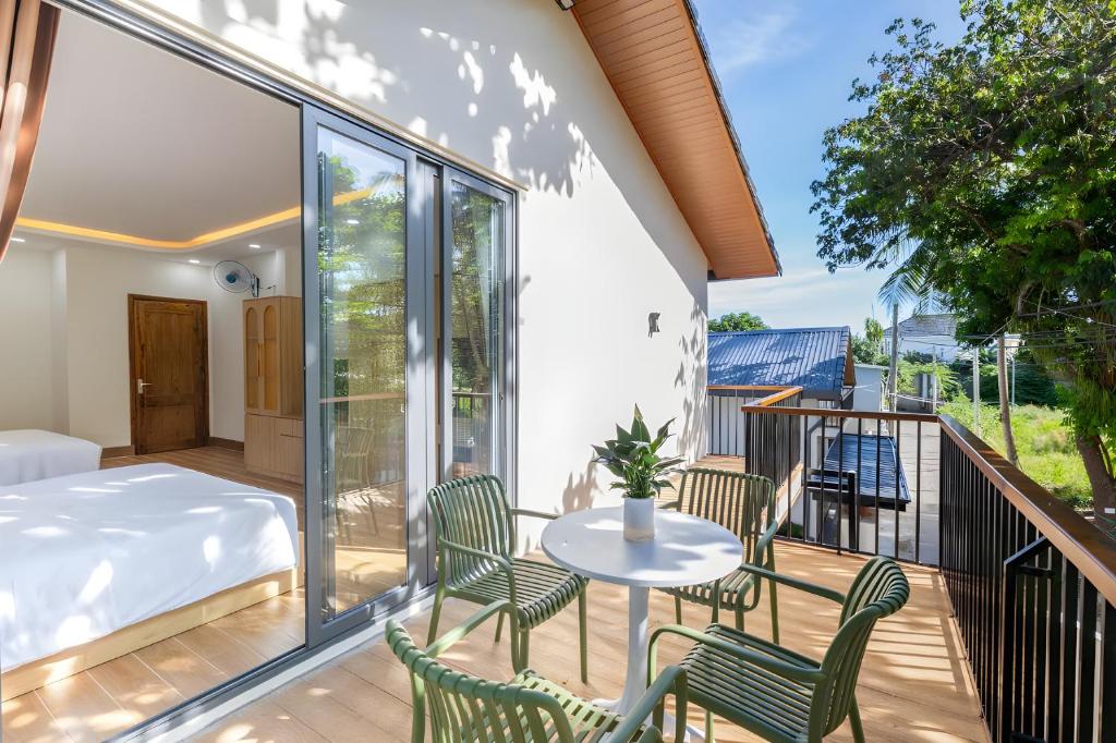 a room with a balcony with a table and chairs at Happy House Villa Phu Quoc in Phú Quốc