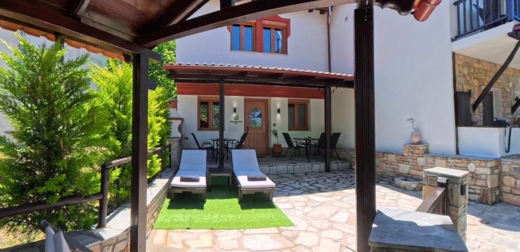 a patio with chairs and a house at Villa del Vino in Mikrós Prínos