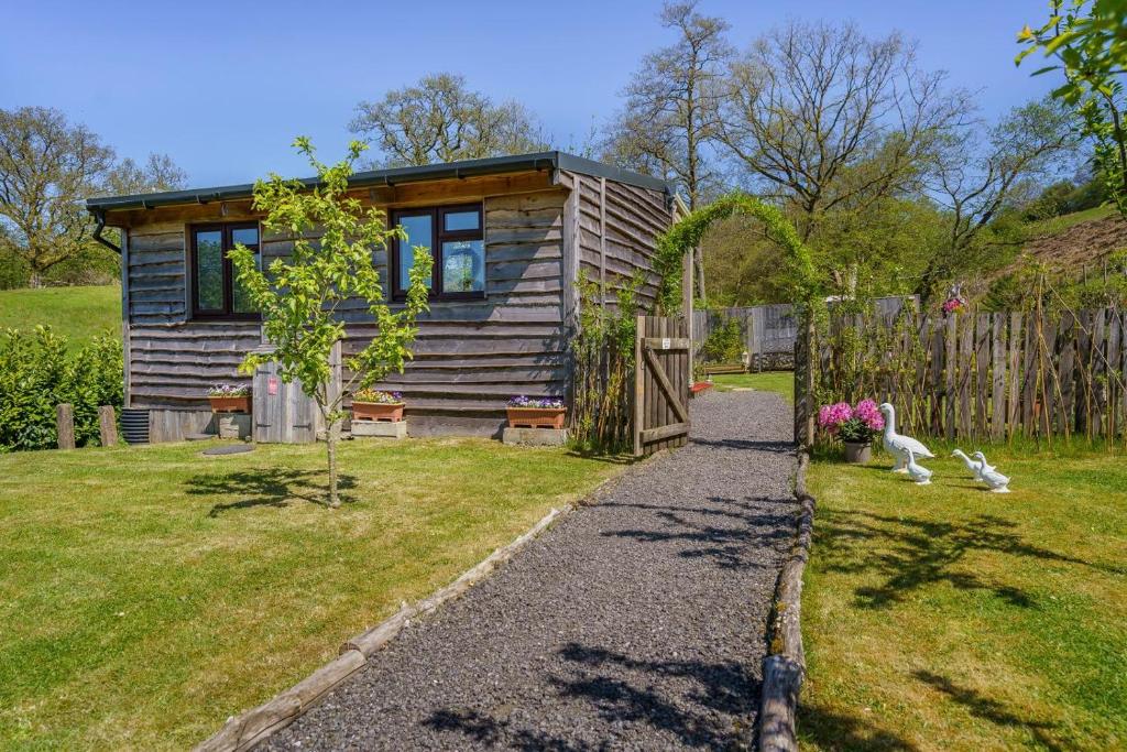 a small wooden house with a fence in a yard at 1 Bed in Llandovery oc-88603 in Cynghordy