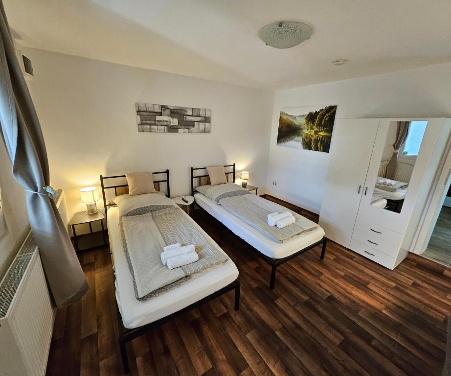two beds in a room with wooden floors at Apartment "North Star" in Dinkelsbühl