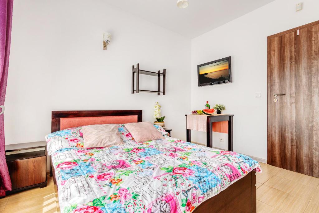 a bedroom with a bed with a colorful comforter at Pokoje JANTARUS in Jantar
