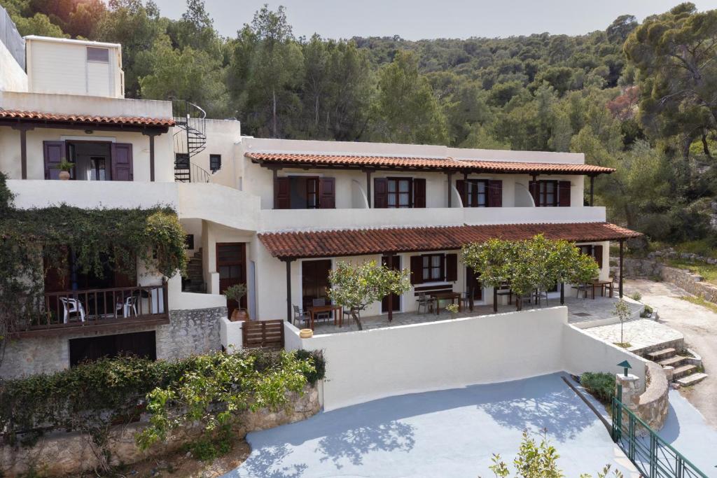 an exterior view of a house with a swimming pool at Alkyoni Forest Rooms in Skala