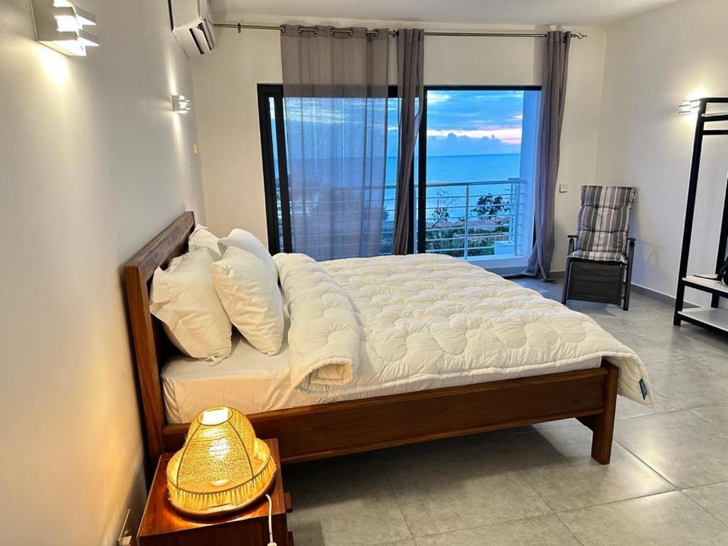 a bedroom with a bed with a view of the ocean at Didas Villa Zanzibar in Zanzibar City