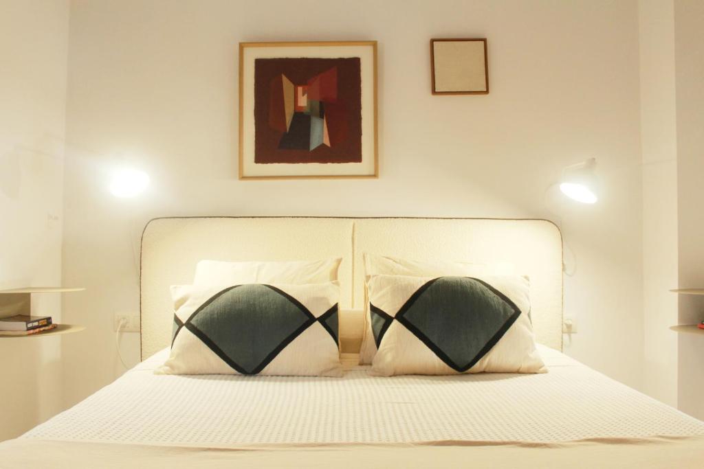a bedroom with a white bed with two pillows at La Duquesita - Ideal para escapada en pareja in Arcos de la Frontera
