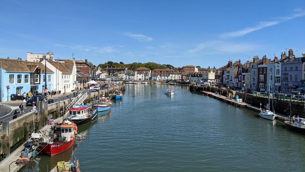 a river with boats docked in a town with houses at Ground floor 1 bed flat in Weymouth