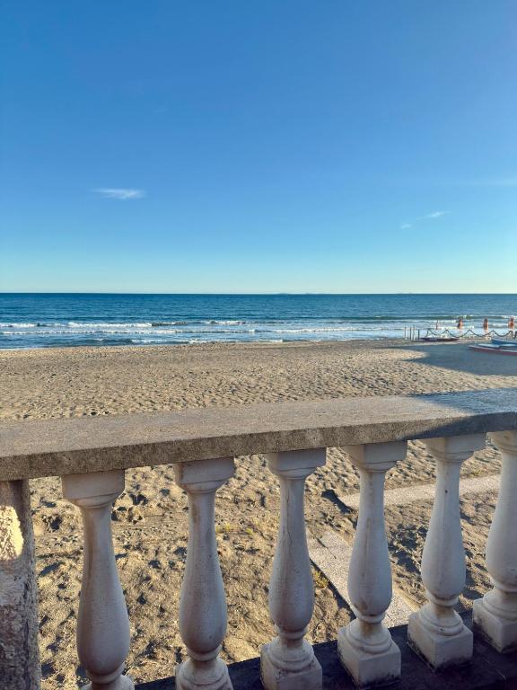 a bench on the beach with the ocean in the background at Terracina Seaside Apartments in Lido Di Fondi
