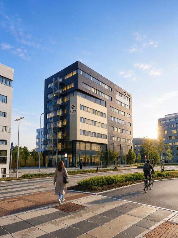a woman walking down a street in front of a building at Stey Stavanger in Stavanger