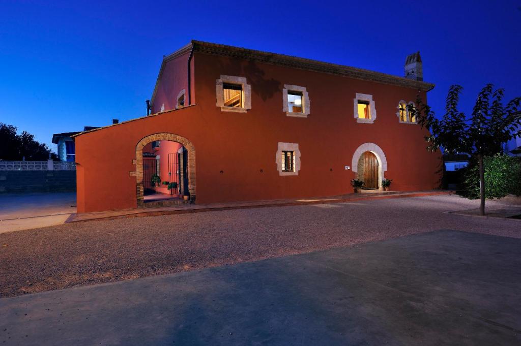 un grande edificio arancione con piano aventh di Masia Casa Roja a Banyeres del Penedes
